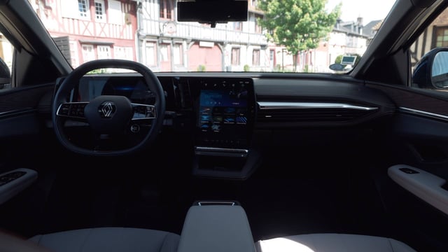 The interior of a Renault Megane E-tech with the car parked in a village.