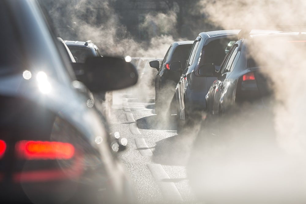 Autos, die auf einer stark befahrenen Straße im Stau stehen und schädliche Emissionen ausstoßen.