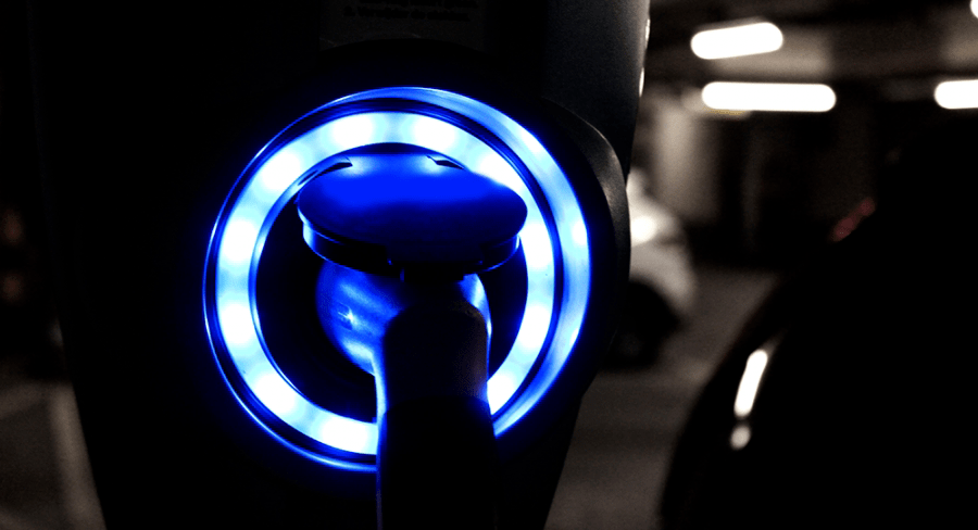 Charging station LED ring lit up around an electric car charging cable.