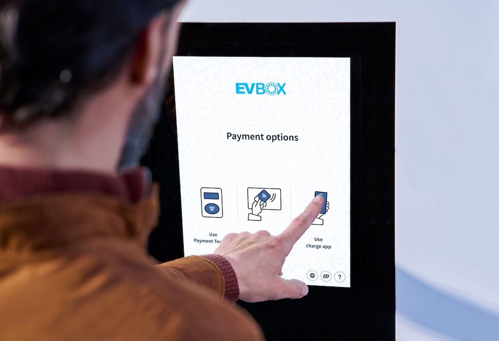 An EV driver selecting his preferred payment method on the touch screen of an EVBox Troniq Modular fast charging station.