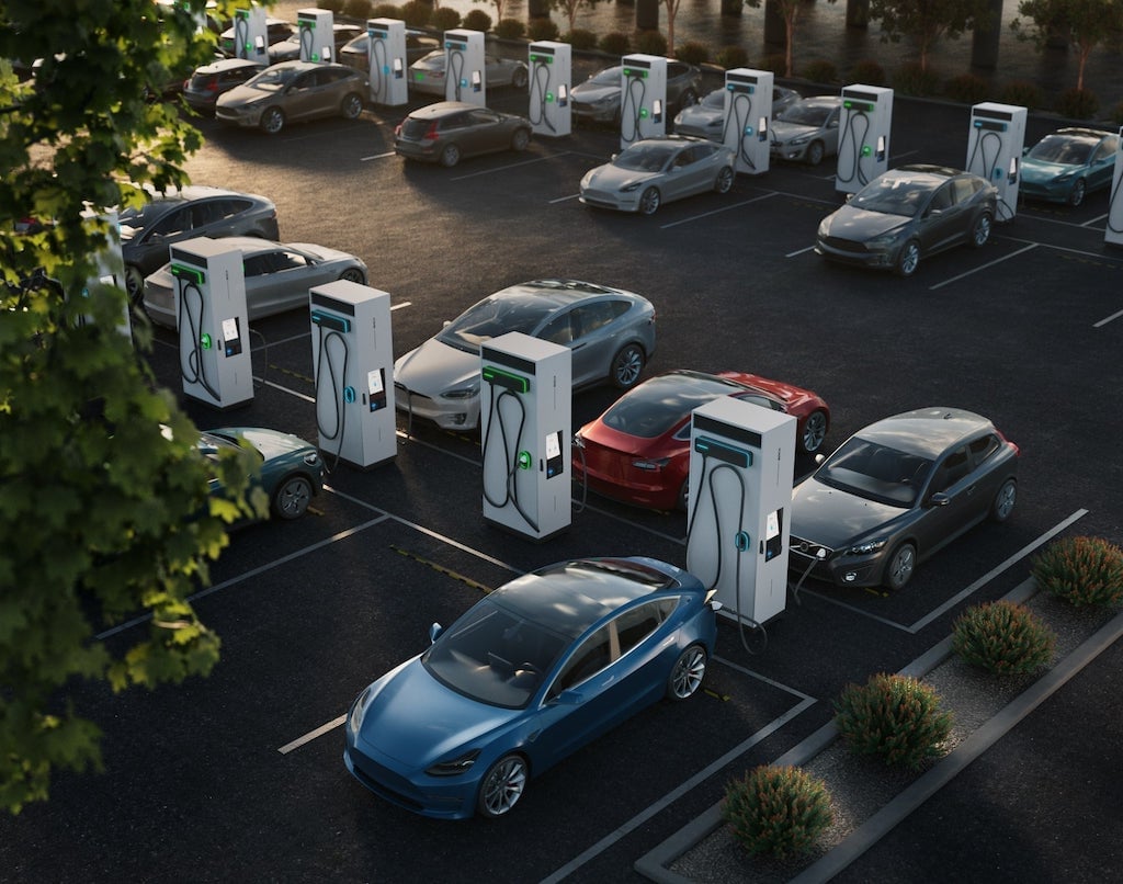 A parking area filled with cars charging at EVBox Troniq Modular fast charging stations.