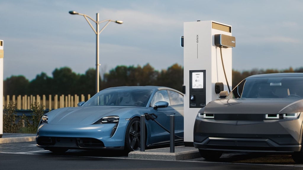 Two EVs are being charged by EVBox Troniq Modular stations with smart charging system.