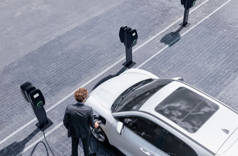 A businessman charging his car with EVBox Liviqo AC charging stations.