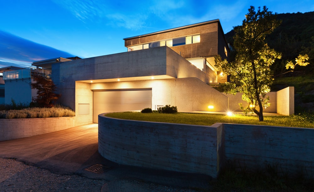 A house at night-time powered by solar energy through battery storage.