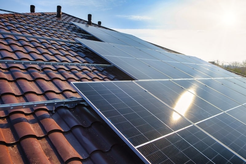 Solar panels are absorbing sunshine and generating energy on a roof.