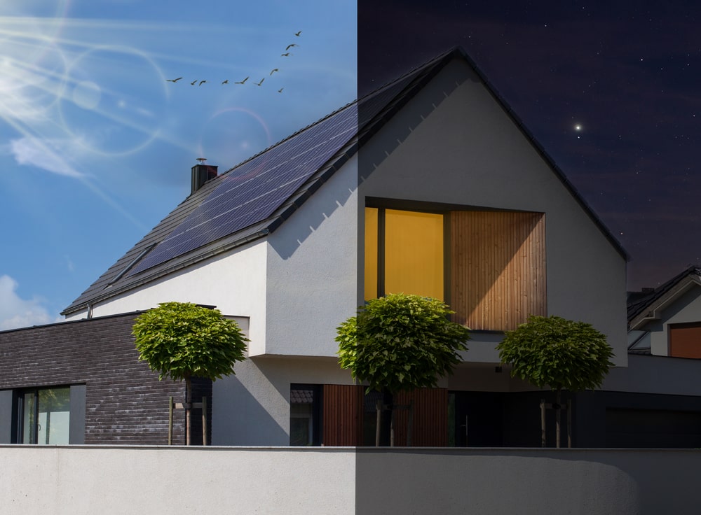 A house with solar panels during the day and night.