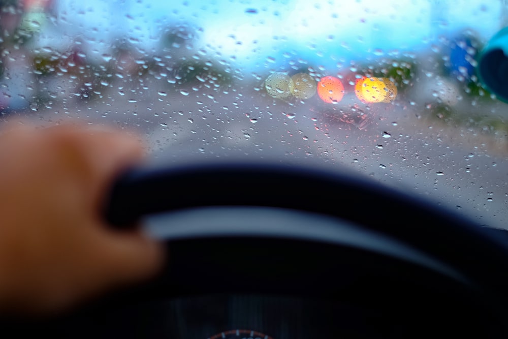 A close up shot of someone driving in the rain.