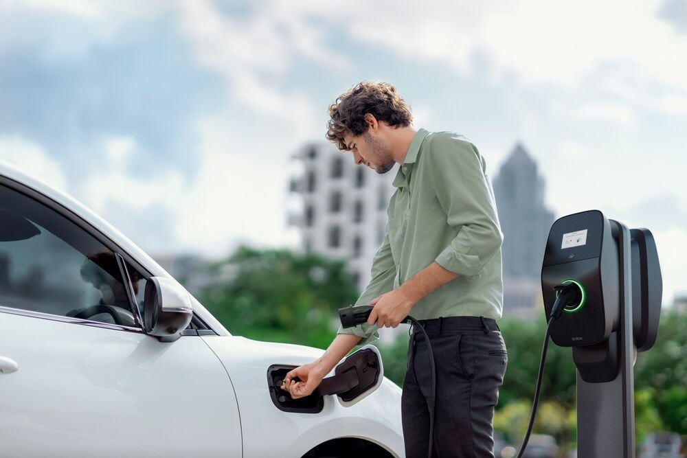 A man charges his EV using an EVBox Liviqo charging station. 