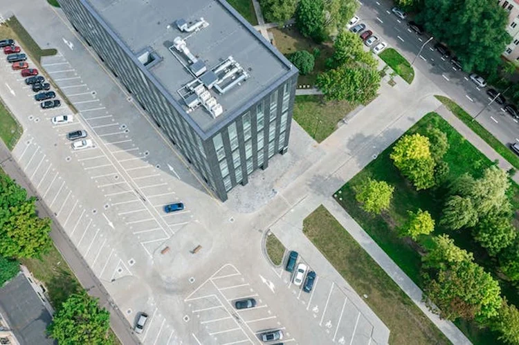 EV charging stations and parking lots that near some office buildings.