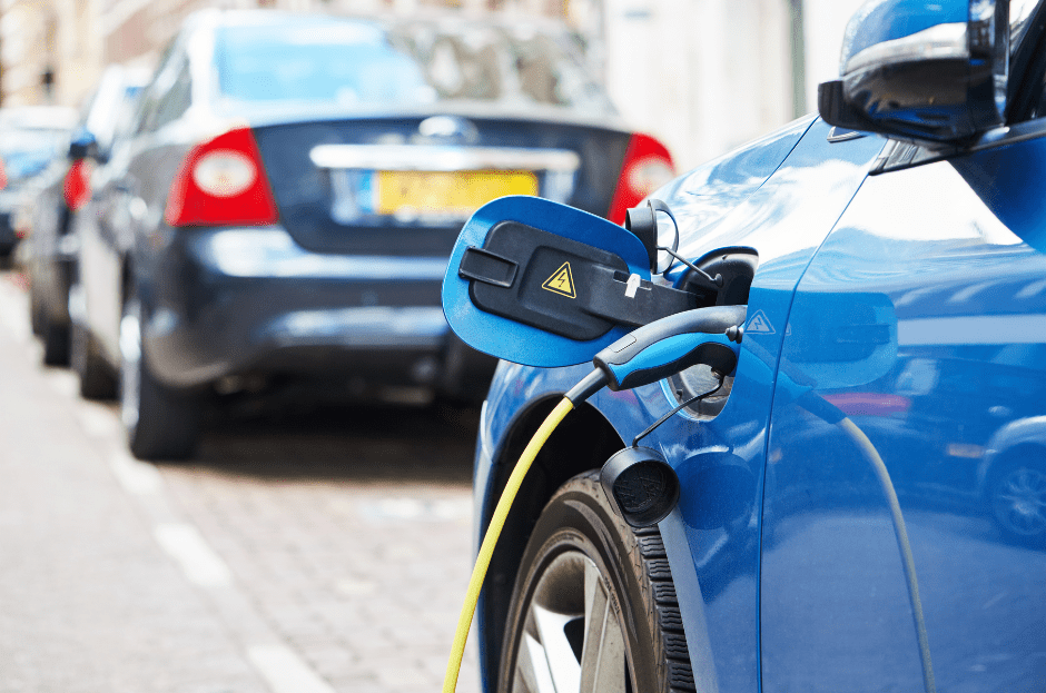 Blauwe elektrische auto wordt opgeladen.