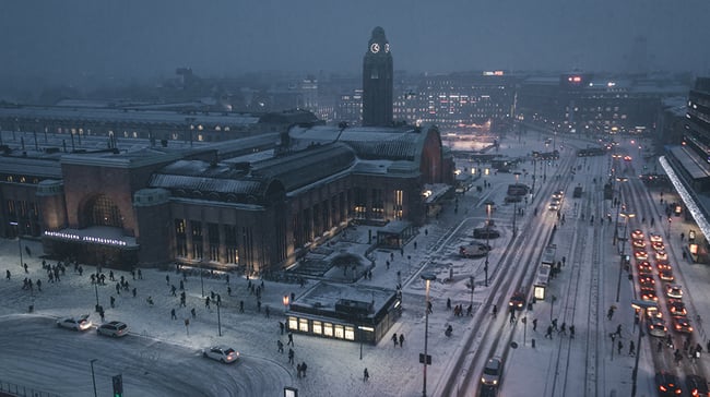 An aerial shot of a city in Finland at night during winter time