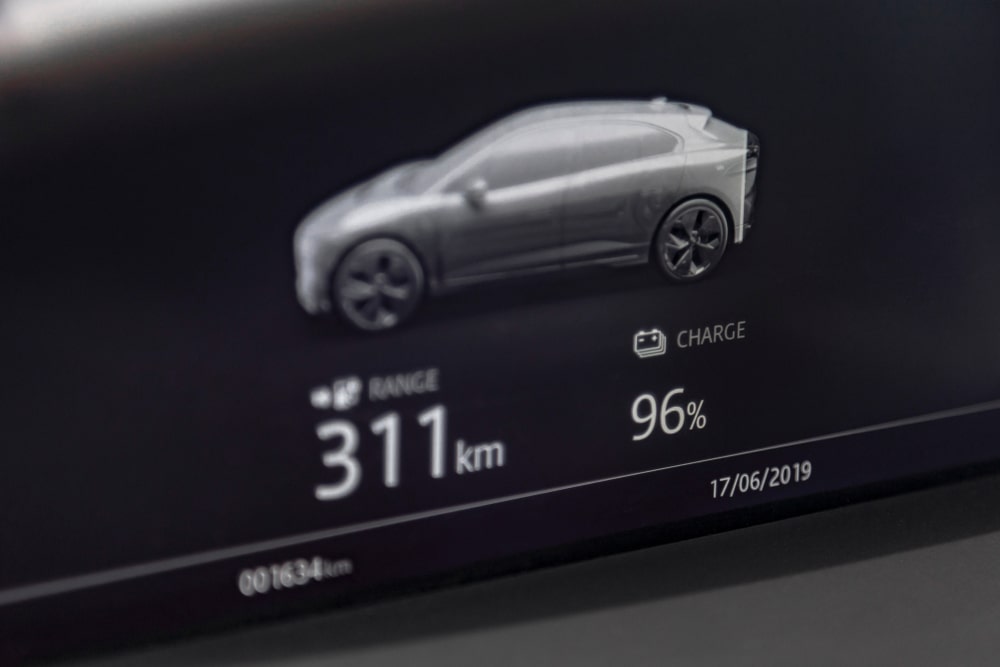 The display screen of an EV showing battery charge level and range.