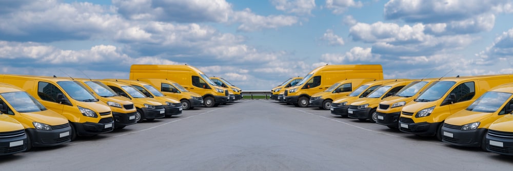 Yellow delivery vans parked in a rows.