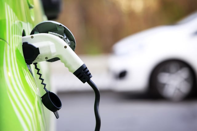 Green electric car being charged