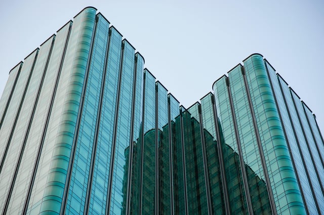 das Äußere eines großen Bürogebäudes mit grünlichen Fenstern