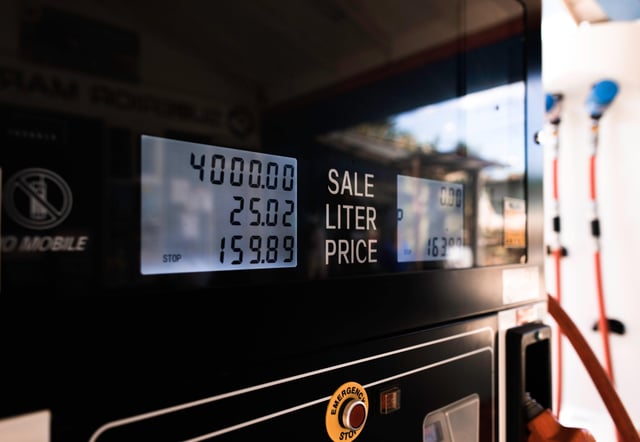 Imagen de primer plano de una bomba de gasolina, que muestra las etiquetas de litro y precio.