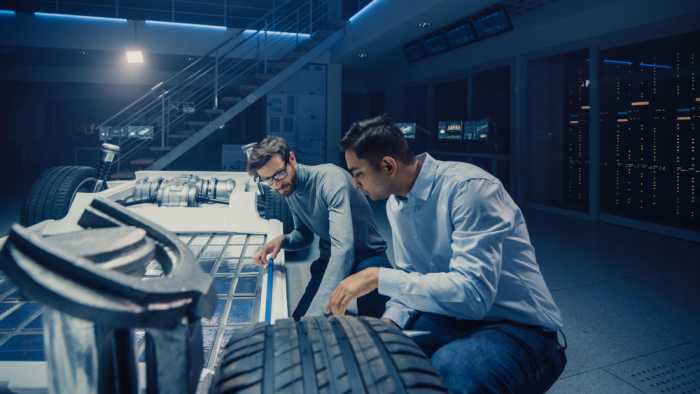 Engineers working on designing a battery pack for a new electric car in a lab..